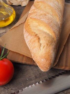 Lezzetli organik baget ekmek bir rustik mutfak masasında Akdeniz malzemelerle