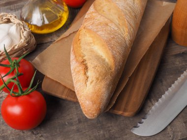 Lezzetli organik baget ekmek bir rustik mutfak masasında Akdeniz malzemelerle