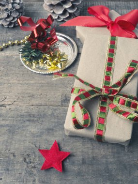 Mevsimsel arka plan olarak kullanılan, ahşap bir zeminde süslemeli Noel hediyeleri.