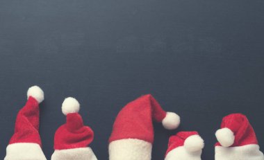 Noel Baba 'nın beş şapkası boş bir karatahtanın üzerinde, yazı ve resimler için boşluk var.