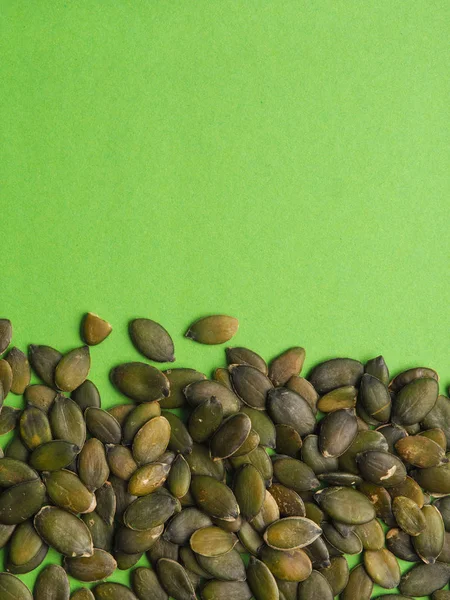 テキストや画像のためのスペース 健康的な食品の概念と緑の背景に有機カボチャの種 — ストック写真