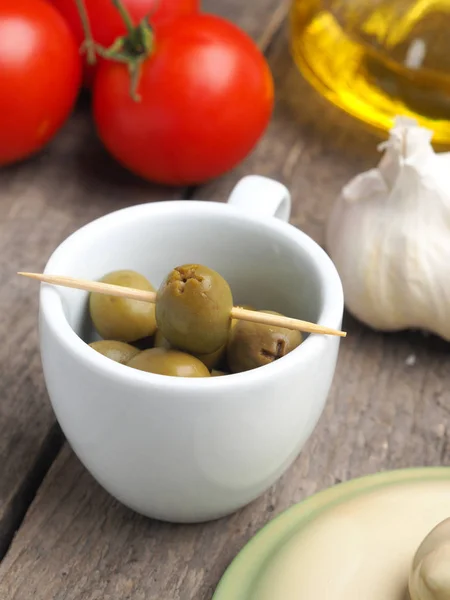 Tasty green olives on a wooden table — Stock Photo, Image