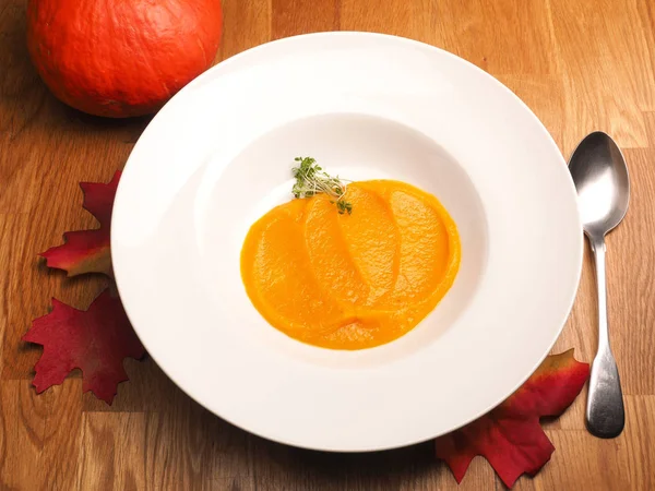 Creamy organic pumpkin soup on a white plate — Stock Photo, Image