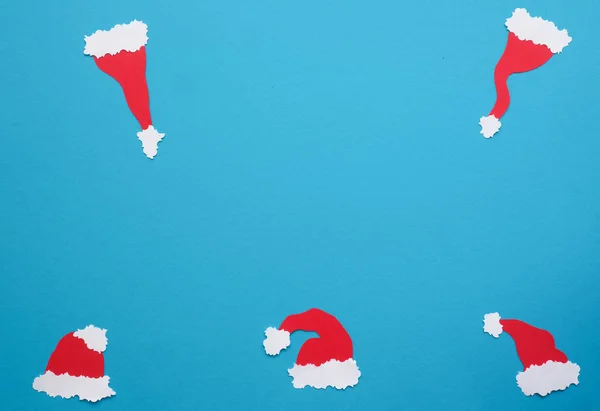 Five handmade hats of Santa on a blue background — Stock Photo, Image