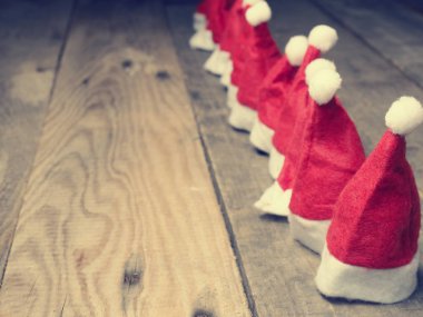 Kırsal bir masada bir sürü Noel Baba şapkası var.