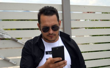 Genç adam bir smartphone kullanarak resmi 