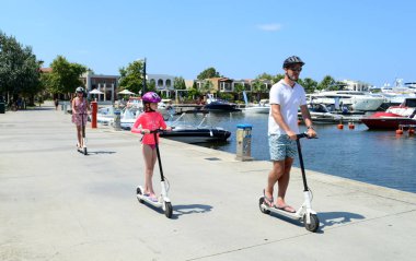 Halkidikya, Yunanistan - 14 Temmuz 2018: elektrikli scooter açık güneşli bir günde kullanarak mutlu aile