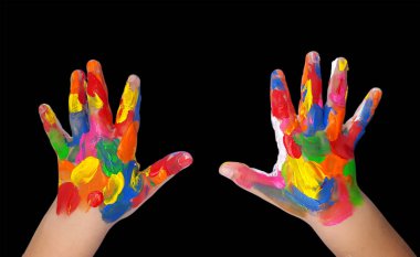 Siyah arka plan üzerinde renkli boya boyalı çocuk eller