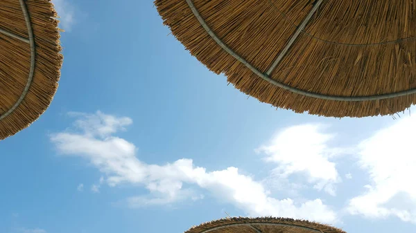 Tři Plážové Slunečníky Vyrobené Slámy Pozadí Modré Oblohy — Stock fotografie