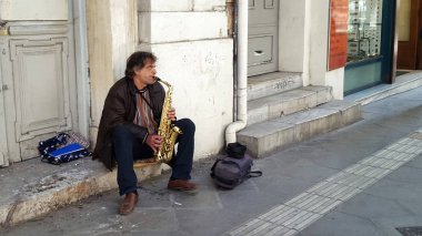 Atina, Yunanistan - 18 Ocak 2019: Atina, Yunanistan sokakta saksafon oynamaya adam