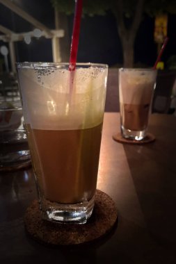 Sütlü, uzun bir bardakta buzlu kahve.