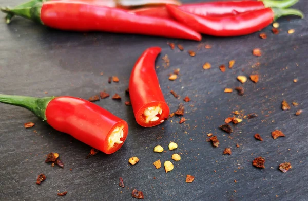 Skär röd chili peppar på en mörk bakgrund — Stockfoto