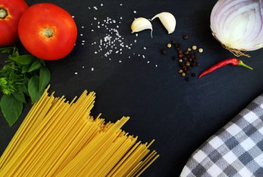 Siyah arka planda spagetti için gıda malzemeleri.