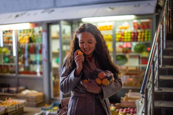 girl with a package of mandarin in the evening market