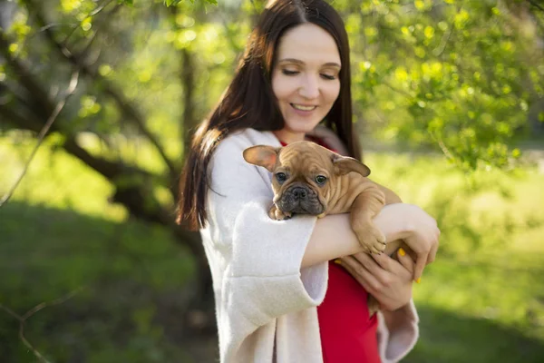 Fiatal nő egy kiskutyával a karjában — Stock Fotó