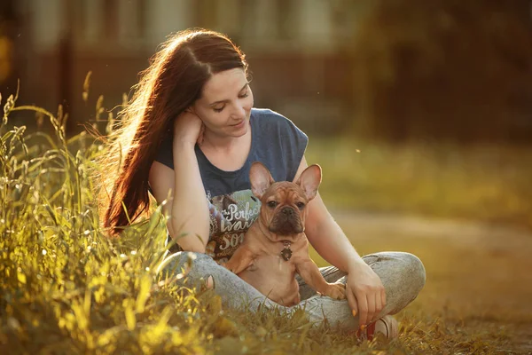 フレンチブルドッグの子犬と一緒に歩く若い女性 — ストック写真