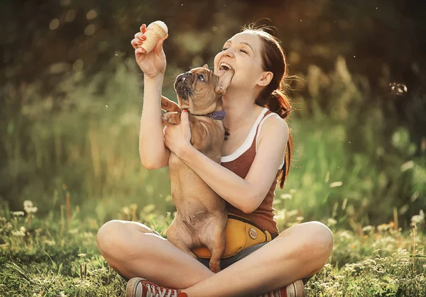 Fiatal nő kezeli kölyök Francia Bulldog fagylaltot — Stock Fotó