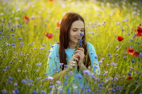 Chica joven en un campo con amapolas rojas — Foto de Stock