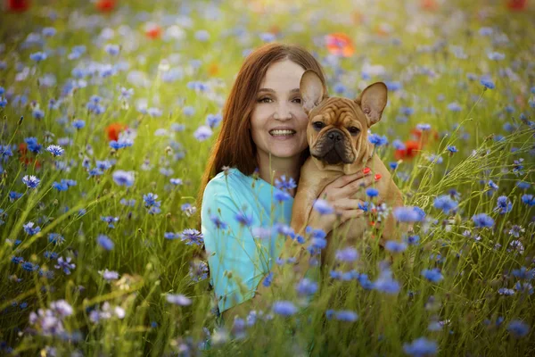 Fiatal lány és a francia bulldog kiskutya egy területen, piros Popp — Stock Fotó