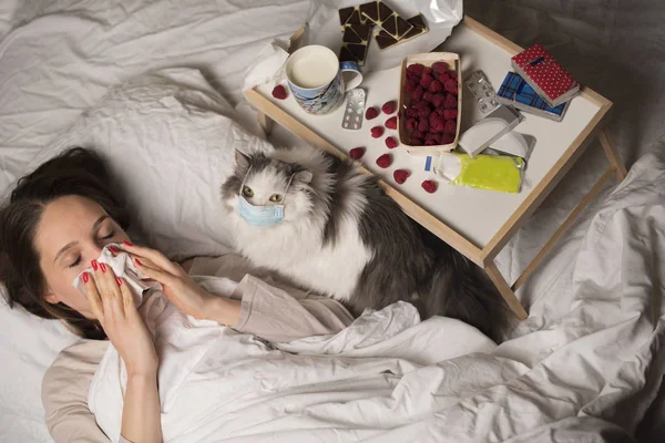 Lány ágyban kezelik a hideg és a macska — Stock Fotó