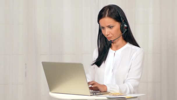 La ragazza con le cuffie sta lavorando al computer . — Video Stock