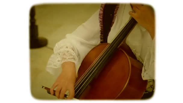 弓を持つ女性は、コントラバスの弦を駆動します。レトロなスタイルの 8 mm フィルム. — ストック動画