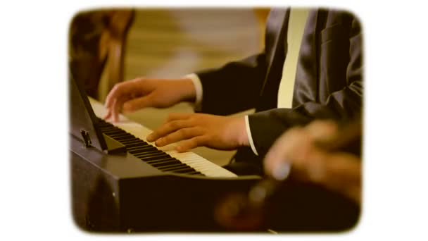 Человек в костюме играет на пианино. фильм в стиле ретро. 8-мм пленка . — стоковое видео