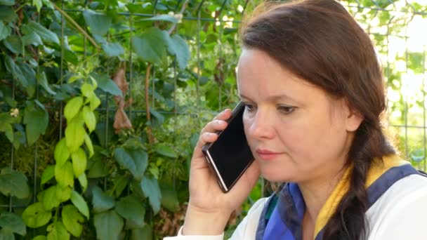 Γυναίκα μιλάει στο τηλέφωνο έξω — Αρχείο Βίντεο