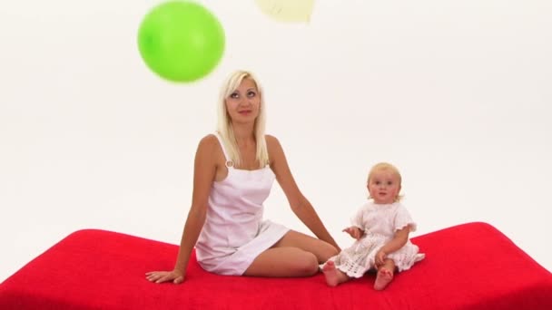На женщину и ребенка девочка падает воздушные шары — стоковое видео