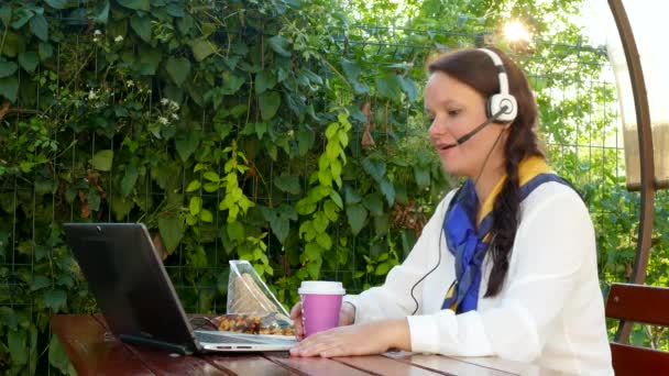 Γυναίκα των επιχειρήσεων σε μια καφετέρια που μιλάτε μέσω ακουστικών — Αρχείο Βίντεο