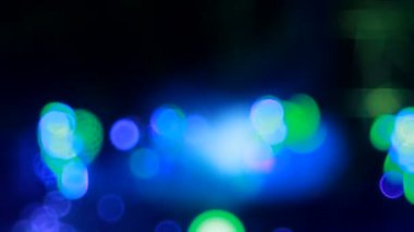 Neon renkli takım elbiseli insanlar sahnede dans eder ve bir kalabalık başlayayım.