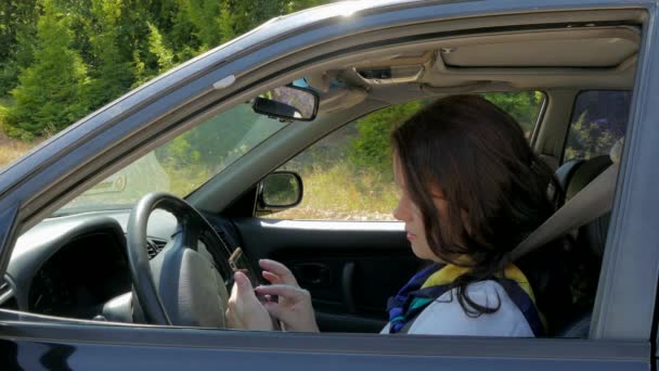 Деловая женщина за рулем, устанавливает координаты в навигаторе — стоковое видео