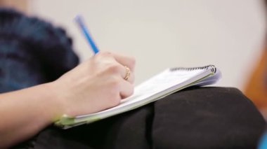 Elinde kalem ve defter tutan kadın..