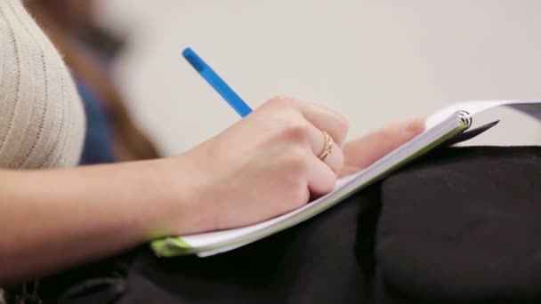 Mujer en una conferencia tomando notas al copybook — Vídeos de Stock