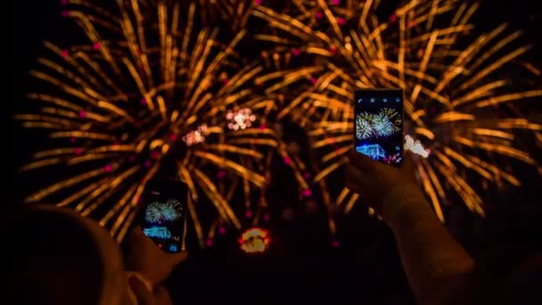 Dos personas haciendo video de fuegos artificiales usando teléfonos inteligentes — Vídeos de Stock