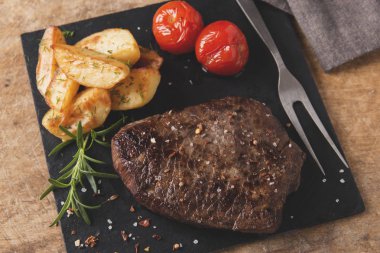 pişmiş ızgara sığır eti biftek ile kızarmış patates ve domates