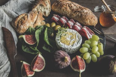 camembert peyniri, incir, jamon, bal ve ev yapımı ekmek, rustik ahşap arka plan üzerinde koyu hizmet kurulu