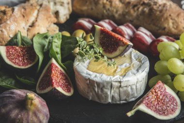 camembert peyniri, incir, prosciutto, bal ve ev yapımı ekmek, rustik ahşap arka plan üzerinde koyu hizmet kurulu