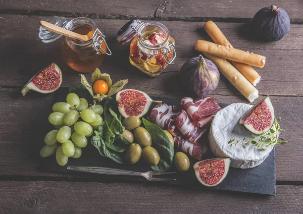 Prosciutto Camembert Cheese Figs Honey Grapes Olives Dark Serving Board — Stock Photo, Image