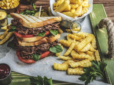 Biftekli sandviç, tost, patates kızartması, sos, Mısır bir ahşap tepsi üzerinde çekti Barbekü