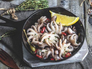 Bebek ahtapot pişmiş, demir tava bölümünde, limon ve baharat ile kavrulmuş