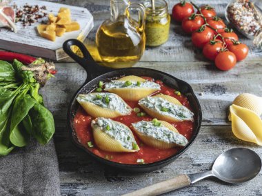 pişmiş makarna conchiglioni doldurulmuş ıspanak ve peynir, domates sosu