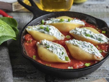 pişmiş makarna conchiglioni doldurulmuş ıspanak ve peynir, domates sosu