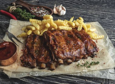 ızgara domuz kaburga bir kesme tahtası, patates kızartması sosu ile