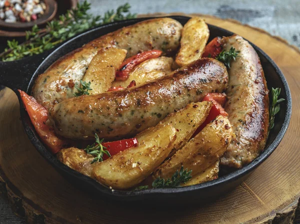 patates kızartması ve bir demir tavada biber tavuk sosis ızgara