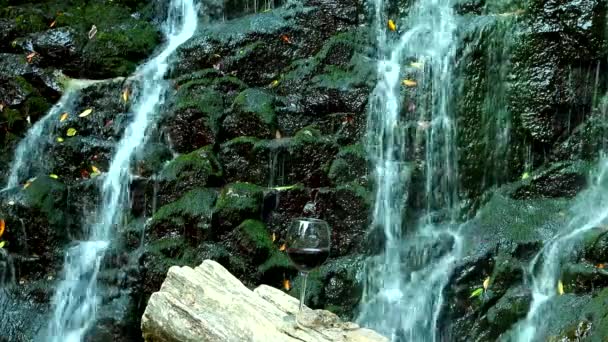 Glas Rött Vin Står Träyta Bakgrunden Klippa Med Ett Vattenfall — Stockvideo