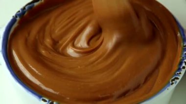 Tahta kaşıkla sıvı karamel karıştırma, yakın