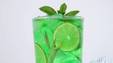 Ferahlatıcı yaz mojito kokteyli limonata buz, tarhun, limon, nane, baloncuk bir bardakta hareket eder.