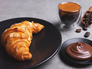 Kahve ve çikolata ezmeli taze kruvasan dilimlenmiş badem.