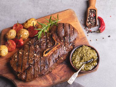 Kemikli ızgara biftek, patates, ahşap domates soslu sos.